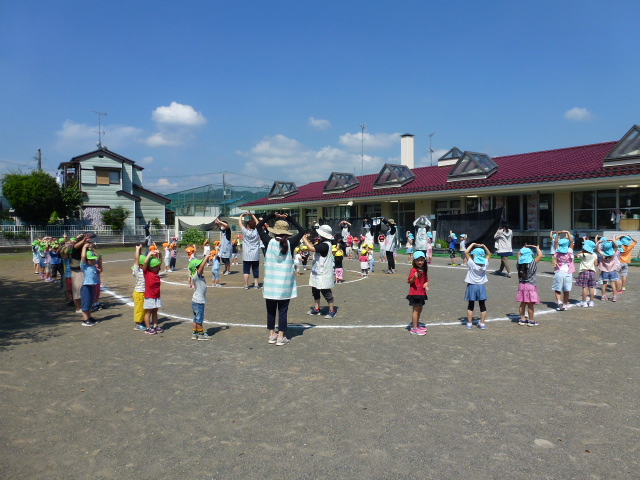 全クラスが園庭に集まり、盆踊りを踊っている。
