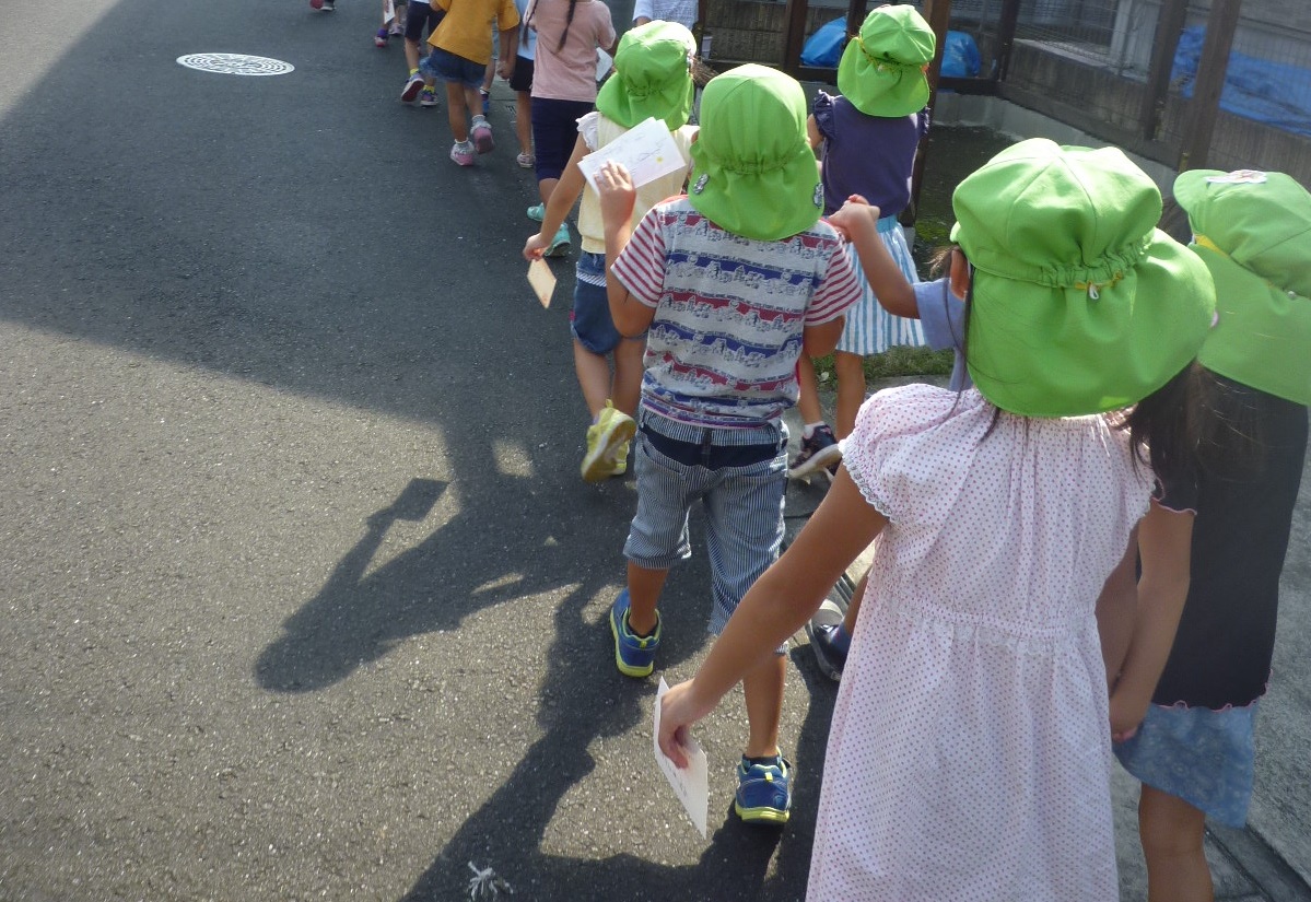 おじいちゃんおばあちゃんに書いたはがきをポストに投函しに行く子どもたち
