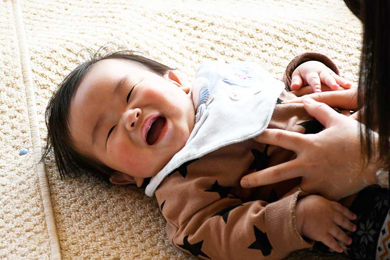 赤ちゃんが寝転んで笑っている画像