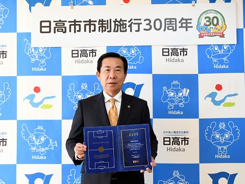 日高総合公園に贈られた記念品を持っている市長の様子