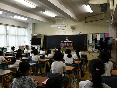 教室で落合弘キャプテンが小学生に向けて授業を行う様子