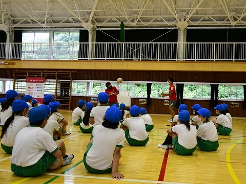 体育館でハートフルクラブコーチの話を聞く小学生の様子