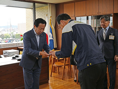 企業版ふるさと納税をしてくださった事業者から目録を受け取る市長
