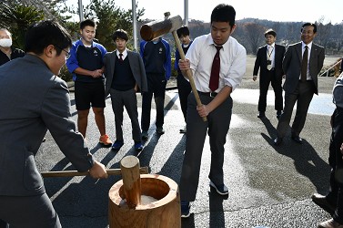 生徒の餅つきを見学している写真