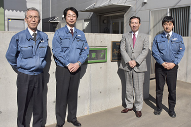 会社の看板の前で市長と社員の皆さんで撮影した写真