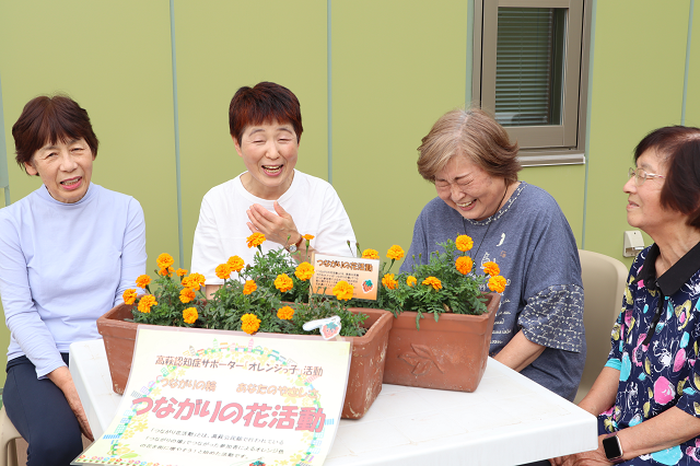 オレンジっ子のみなさんがマリーゴールドの花を囲んで談笑しているところ