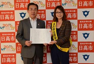 日高市交通安全母の会会長の新原さんから交通安全知事メッセージを受け取る様子の写真2