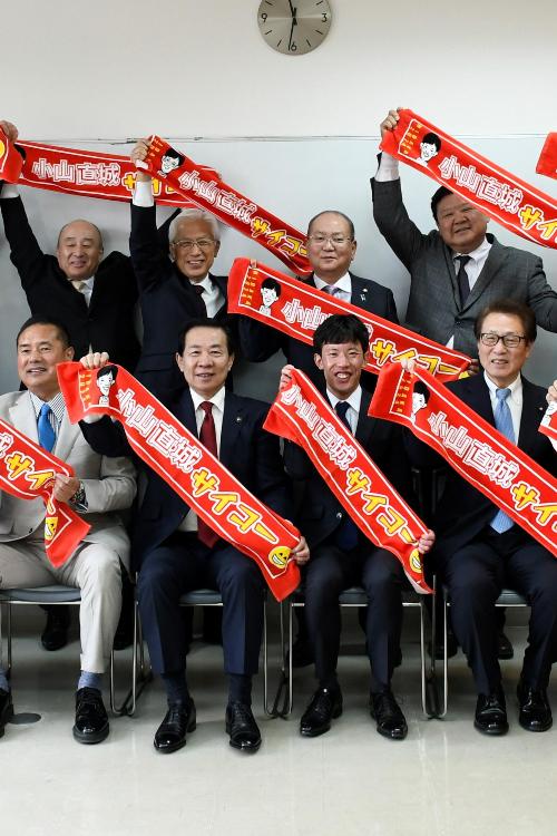 小山直城選手と一緒にサイコータオルを掲げる谷ケ崎市長と実行委員の皆さん
