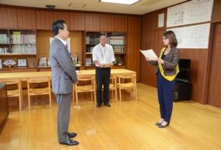 日高市交通安全母の会会長の新原さんから交通安全知事メッセージを受け取る様子の写真1