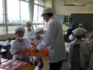 市長の給食当番牛乳配ぜん中の写真
