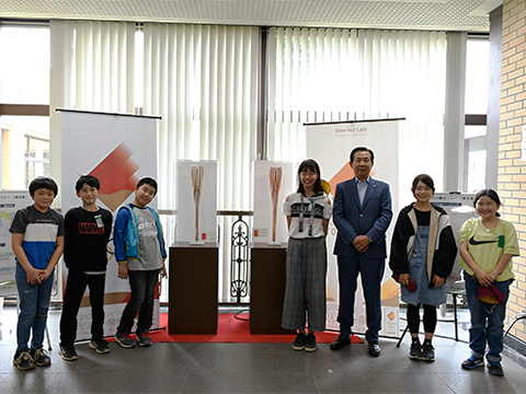 聖火リレーのトーチの展示を取り囲んだ市長と市内小学生の記念撮影