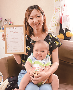子どもを抱えた母親が手に資格証明書を持っている