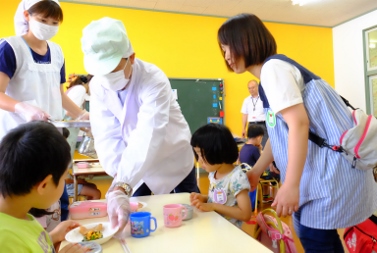 子どもたちに給食を配る市長の写真