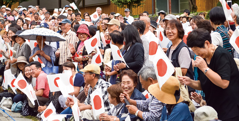 沿道で両陛下を心待ちにする人たち。