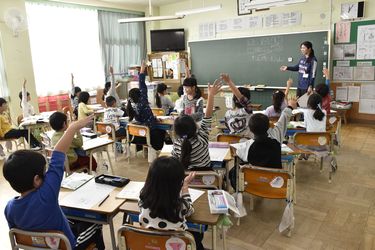 元気に手をあげる児童たちの写真