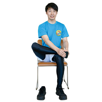 椅子に座って足を組んでいる写真