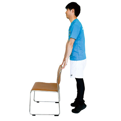 いすを軽く支えた状態でかかとを上げている写真