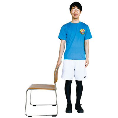 いすを軽く支えて立っている写真
