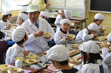 児童と給食を食べている写真