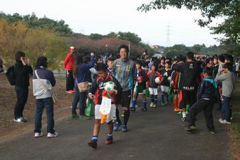 試合後拍手で見送られる両市選手たちの写真