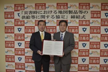 宮崎関東エリア統括部長(右側)と谷ケ崎市長が協定書を持っている写真
