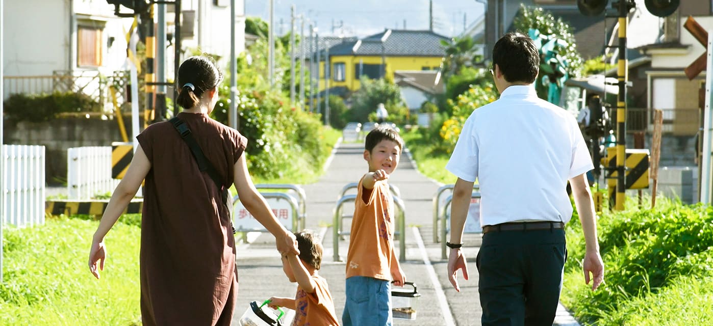 道を歩く家族の画像