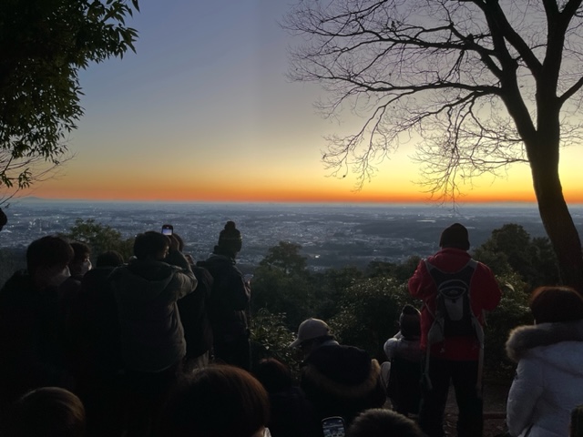 山頂に集まった人々が初日の出を望む様子