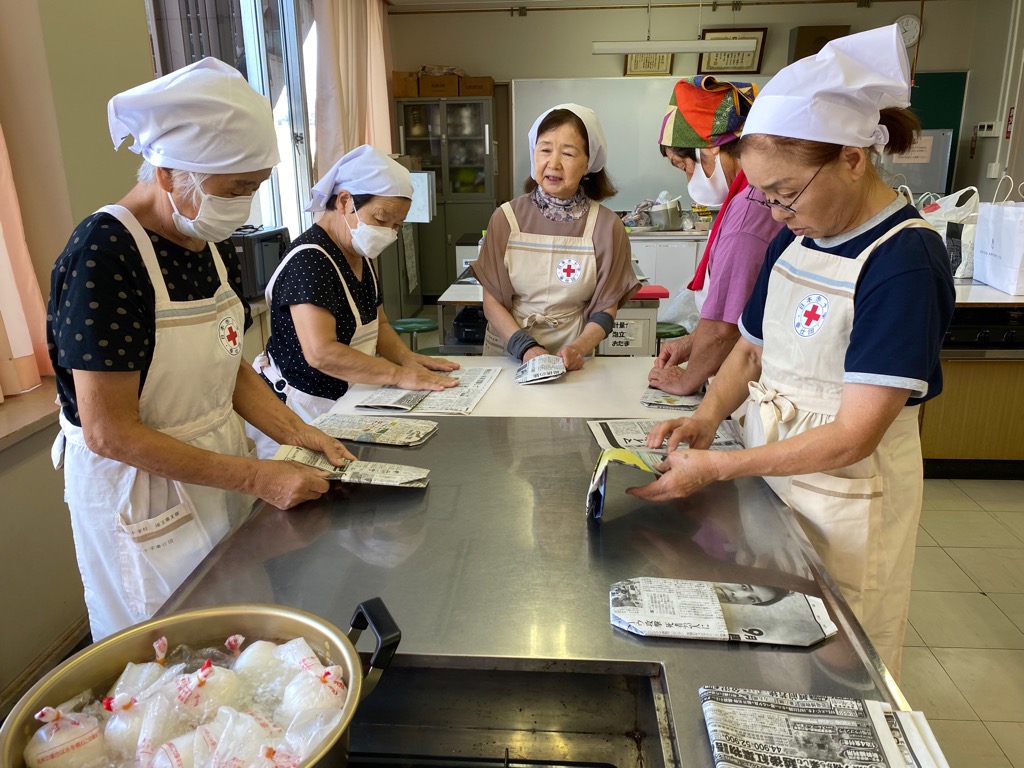 新聞紙でスリッパを作っている様子