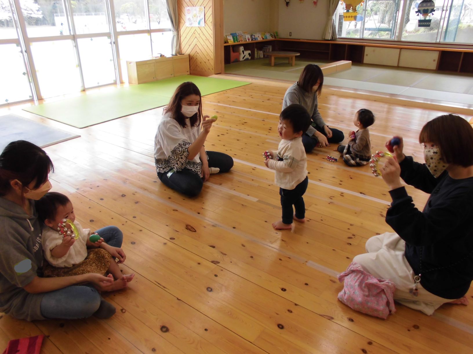 座って鈴を振る参加者