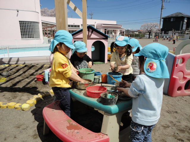 4歳児外で砂遊びをしているところ