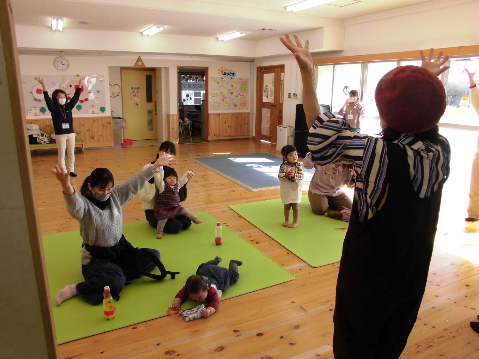 大きく手を挙げて手遊びをする参加者の皆さん