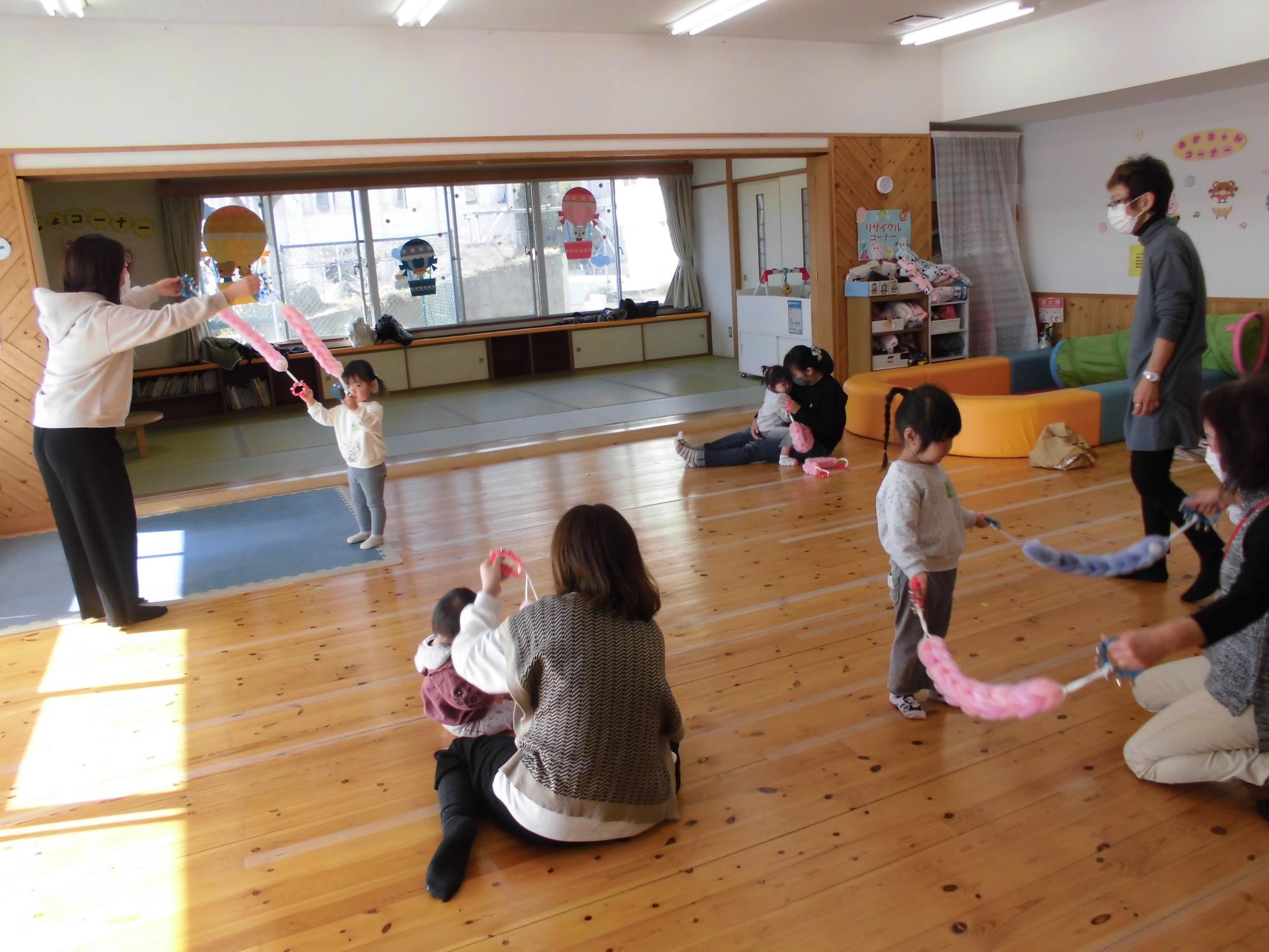 鈴が鳴る道具を上下させて楽しむ参加者