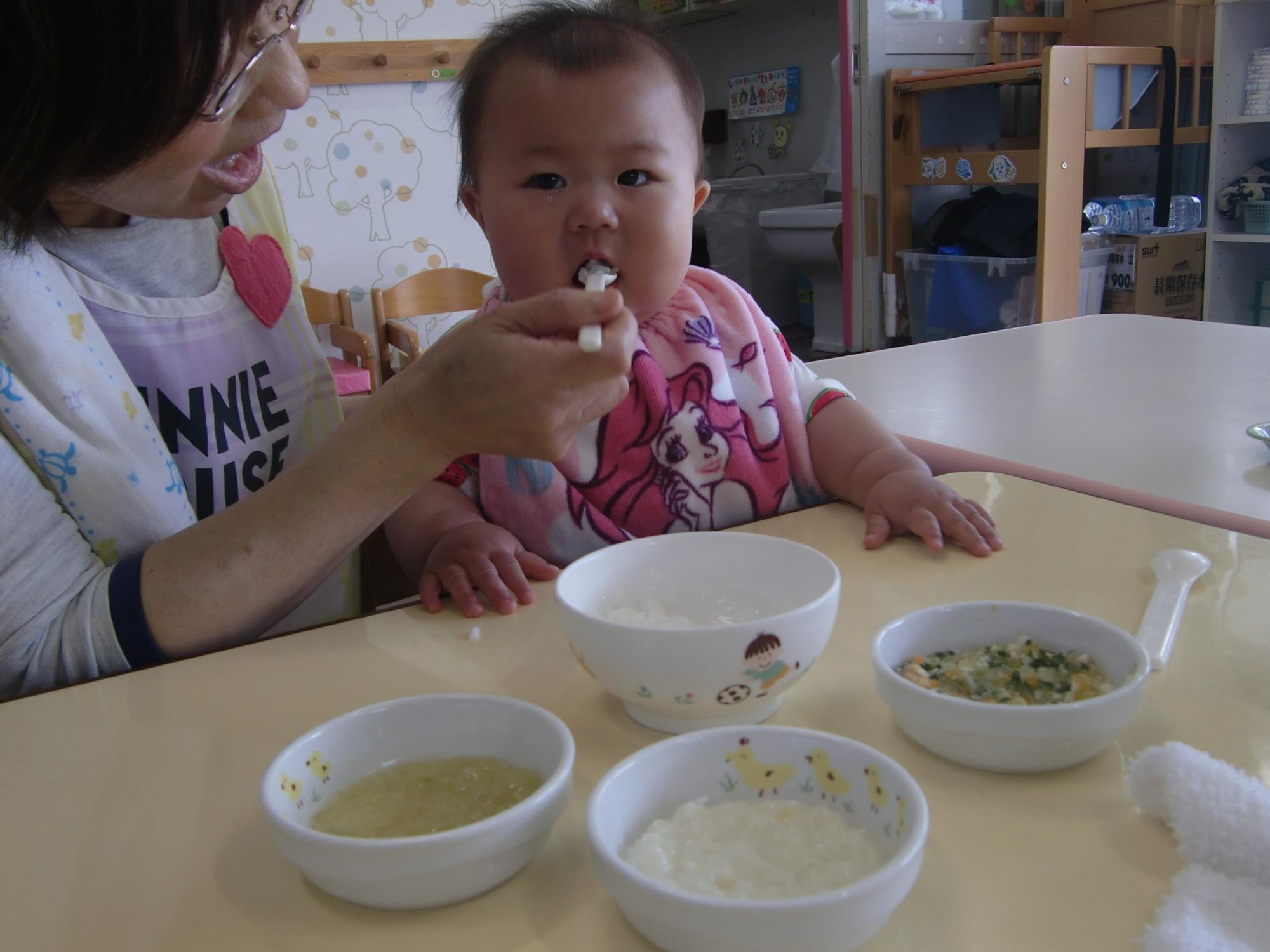 離乳食をスプーンで食べさせてもらっているところ