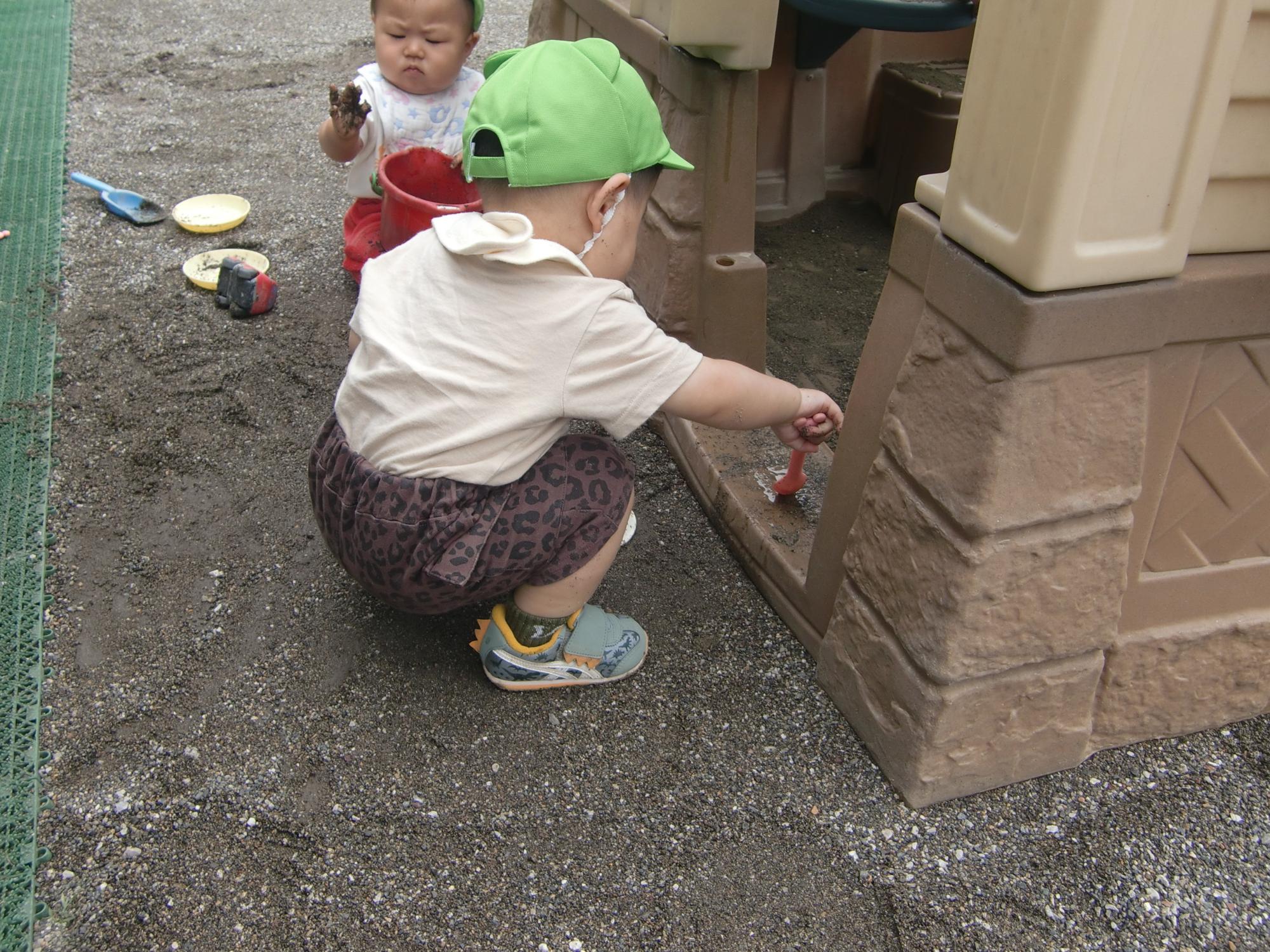 0歳児砂遊びをしているところ