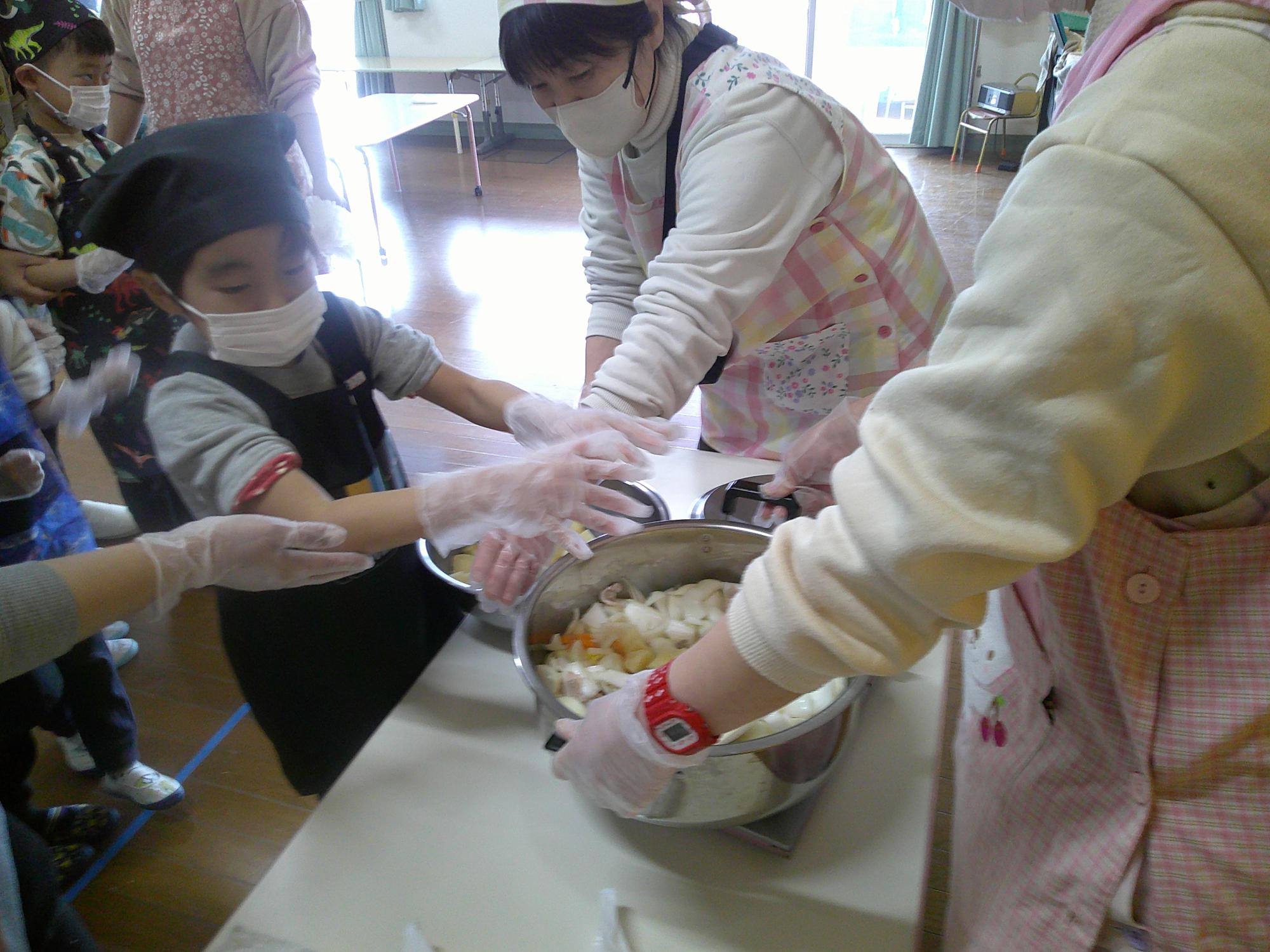 野菜を鍋に入れているところ