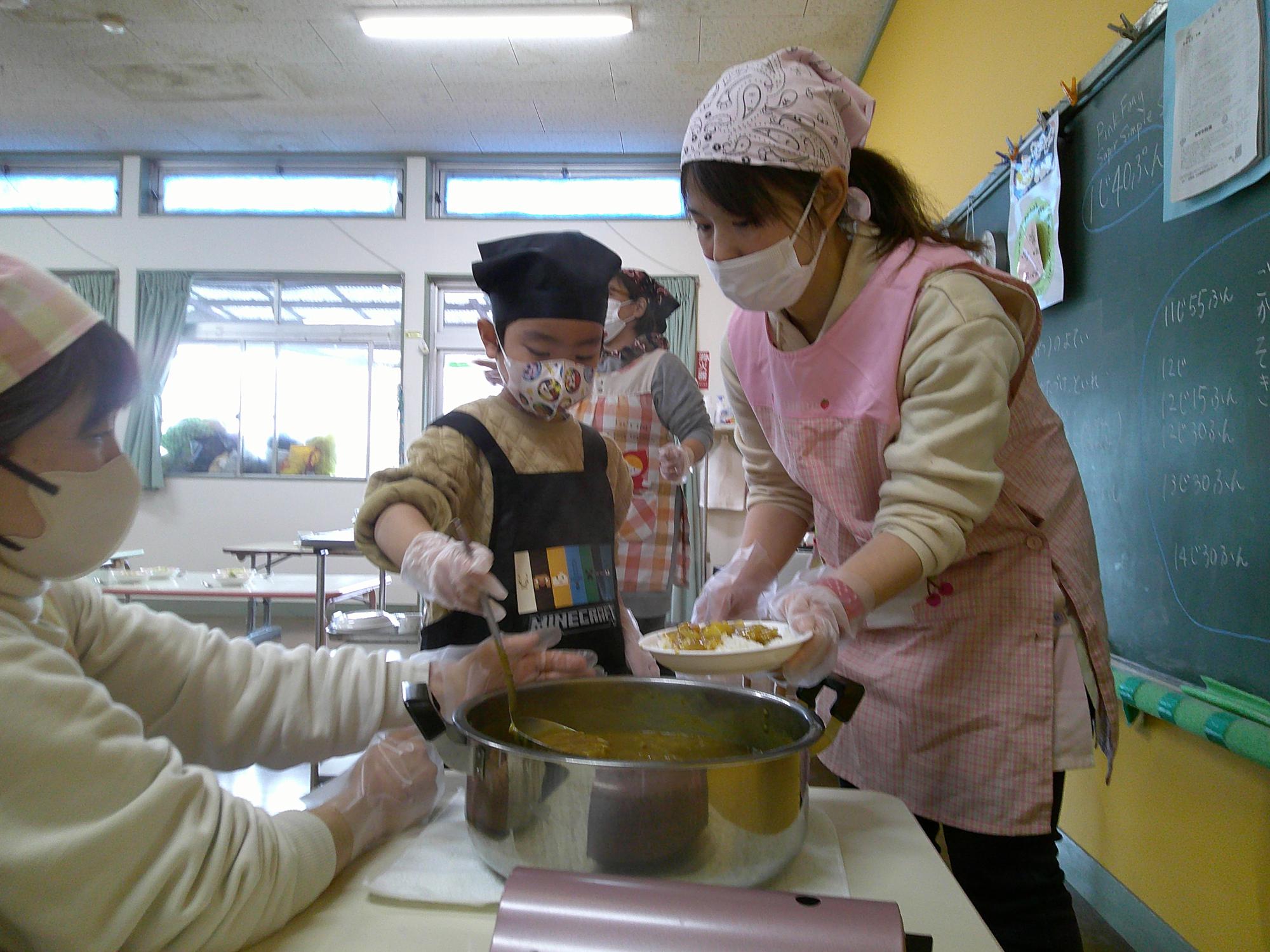 子どもたちが自分でカレーをよそっているところ