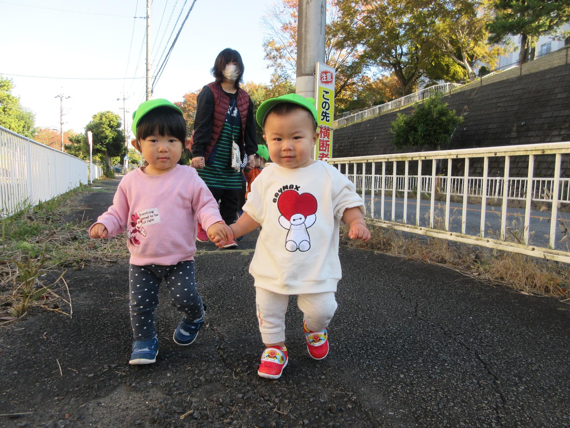0歳児手をつないでお散歩しているところ