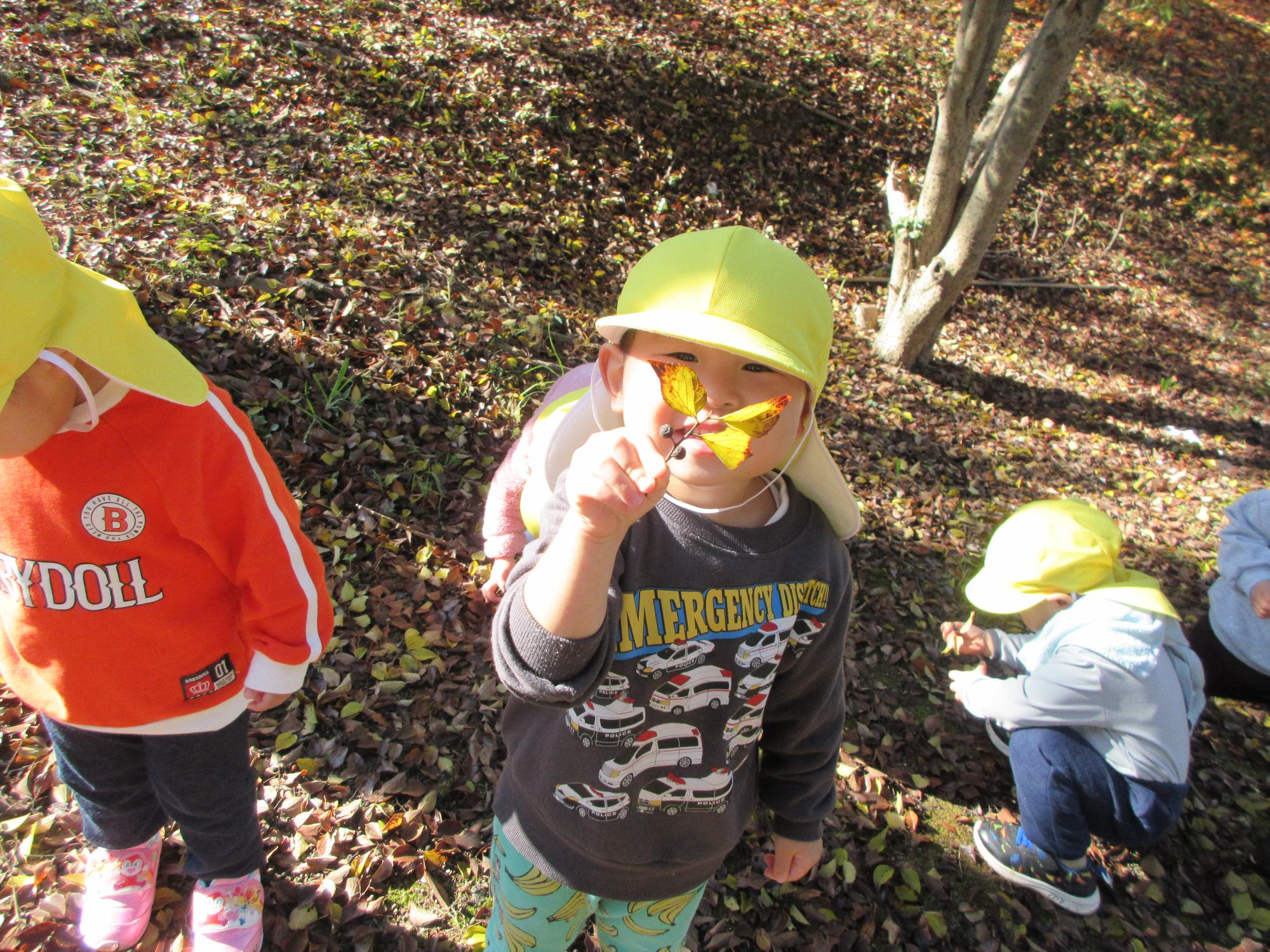 顔の前で見つけた木の実を見せて笑っているところ