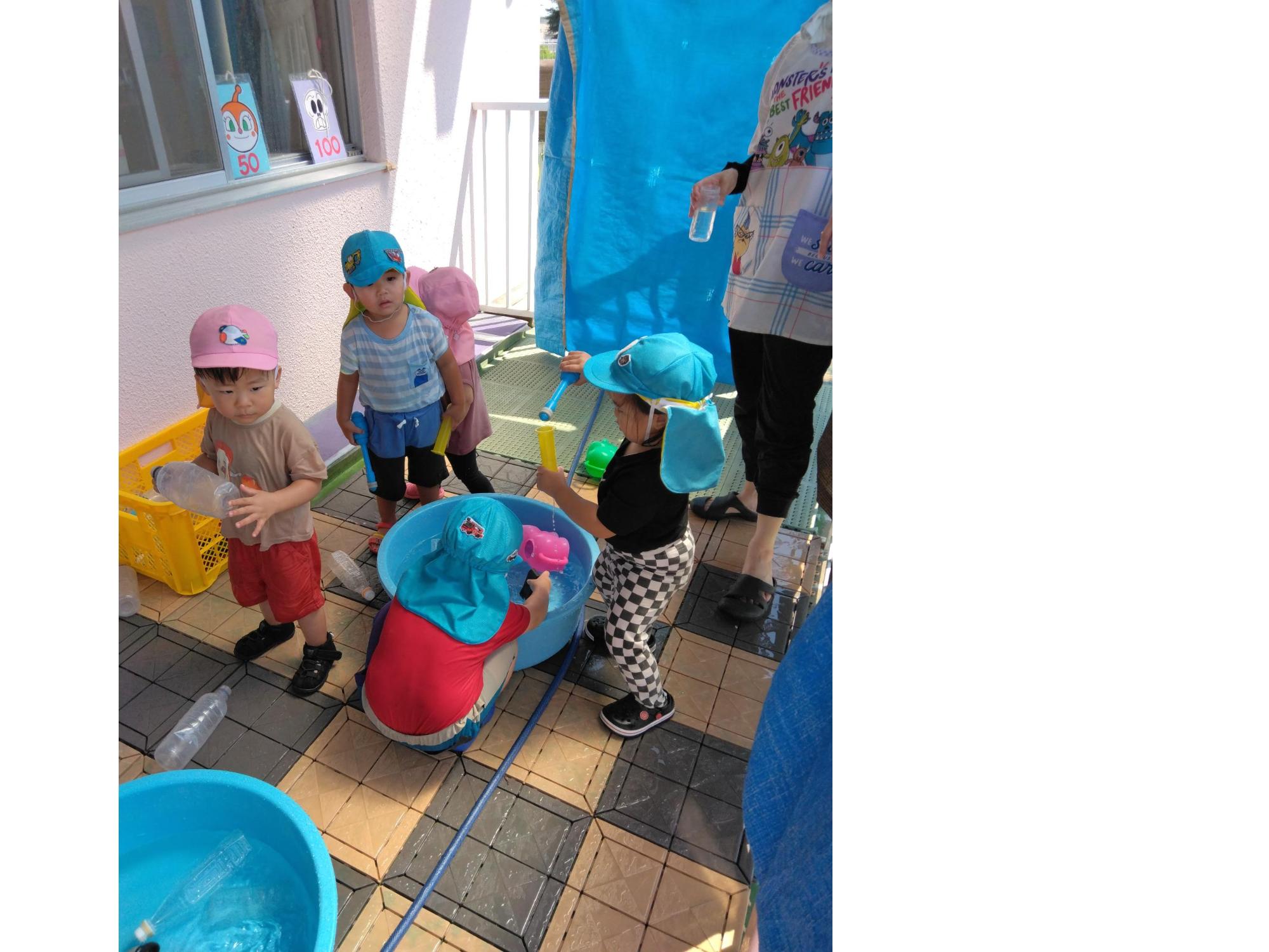 1,2歳児はテラスで水遊びをしました