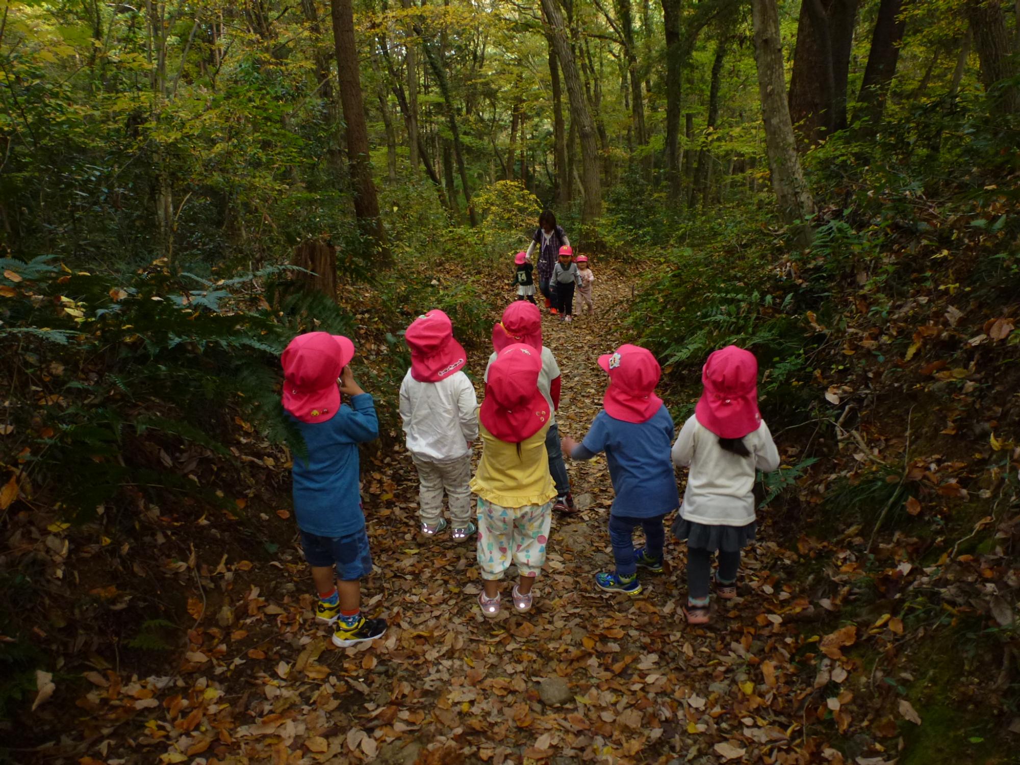 山道を歩くお友達を応援する子どもたちの写真