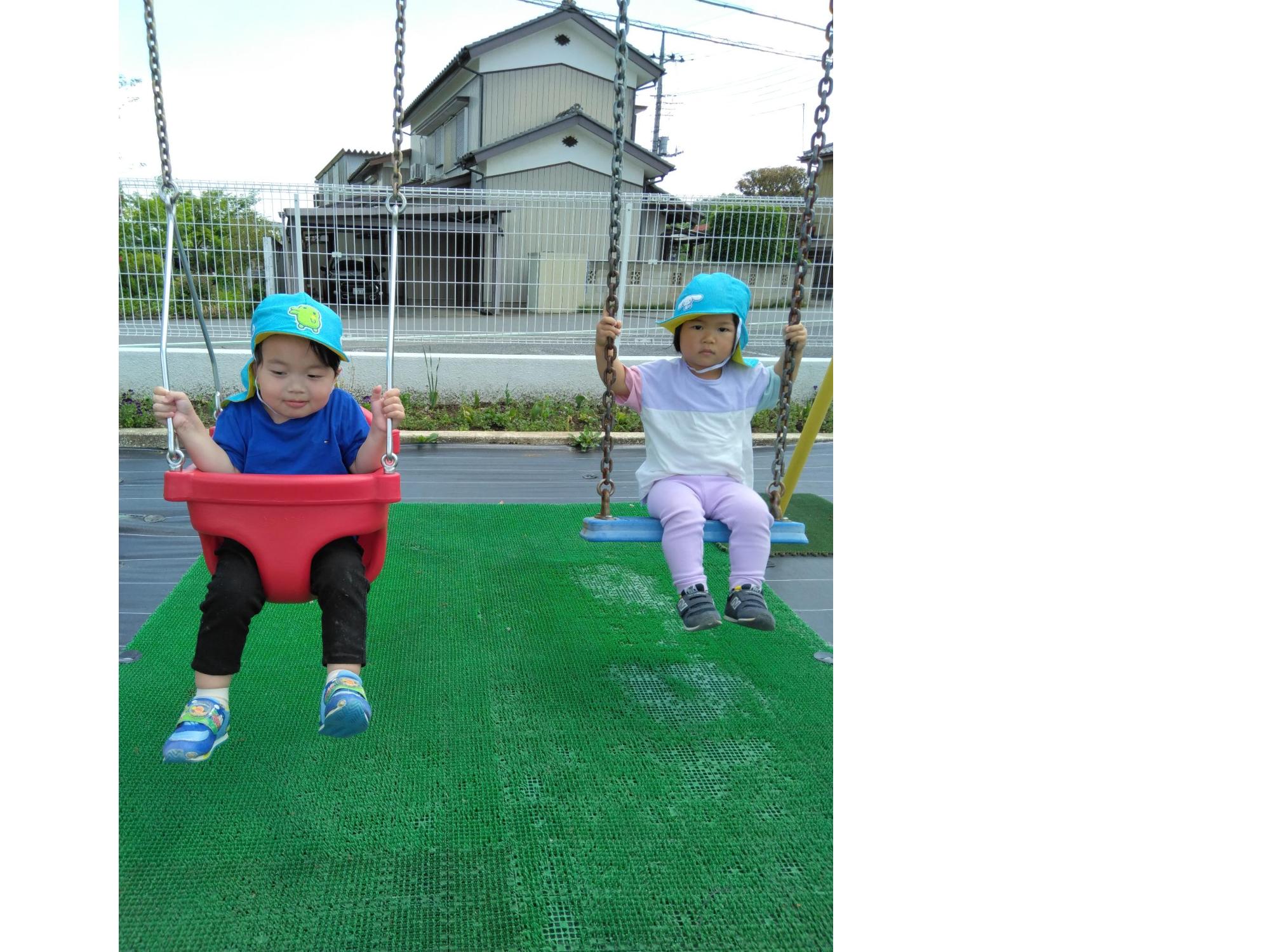 ブランコで遊んでいる2歳児