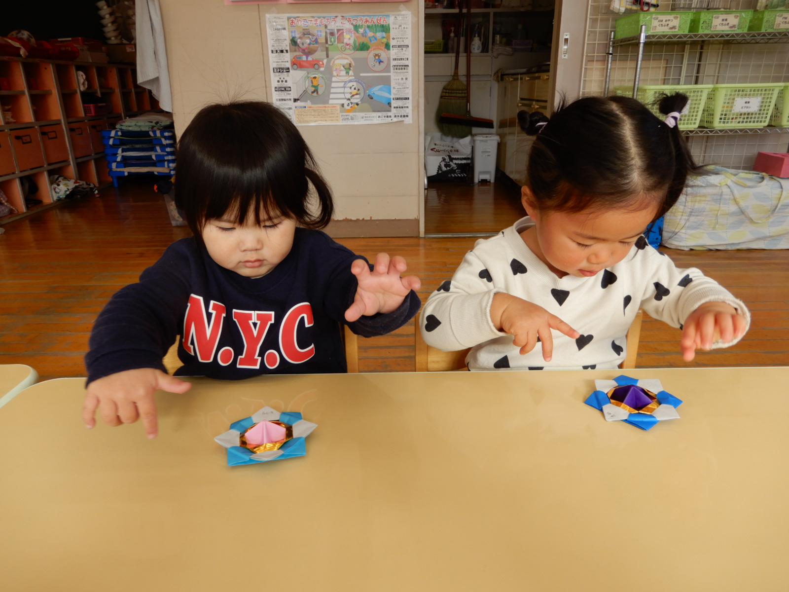 折り紙のこまで遊ぶ1歳児