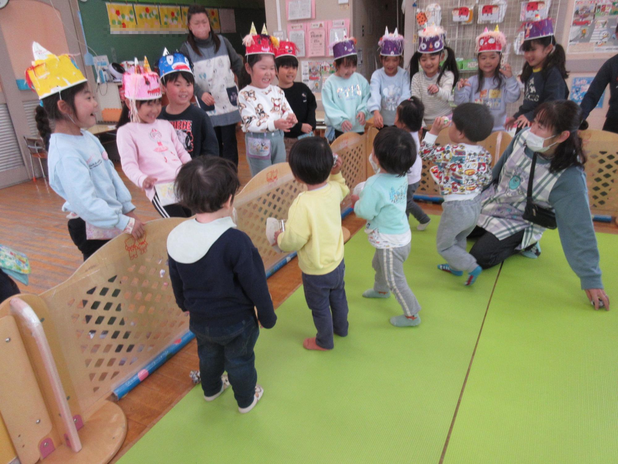 鬼役の年長児に豆まきをしている1歳児