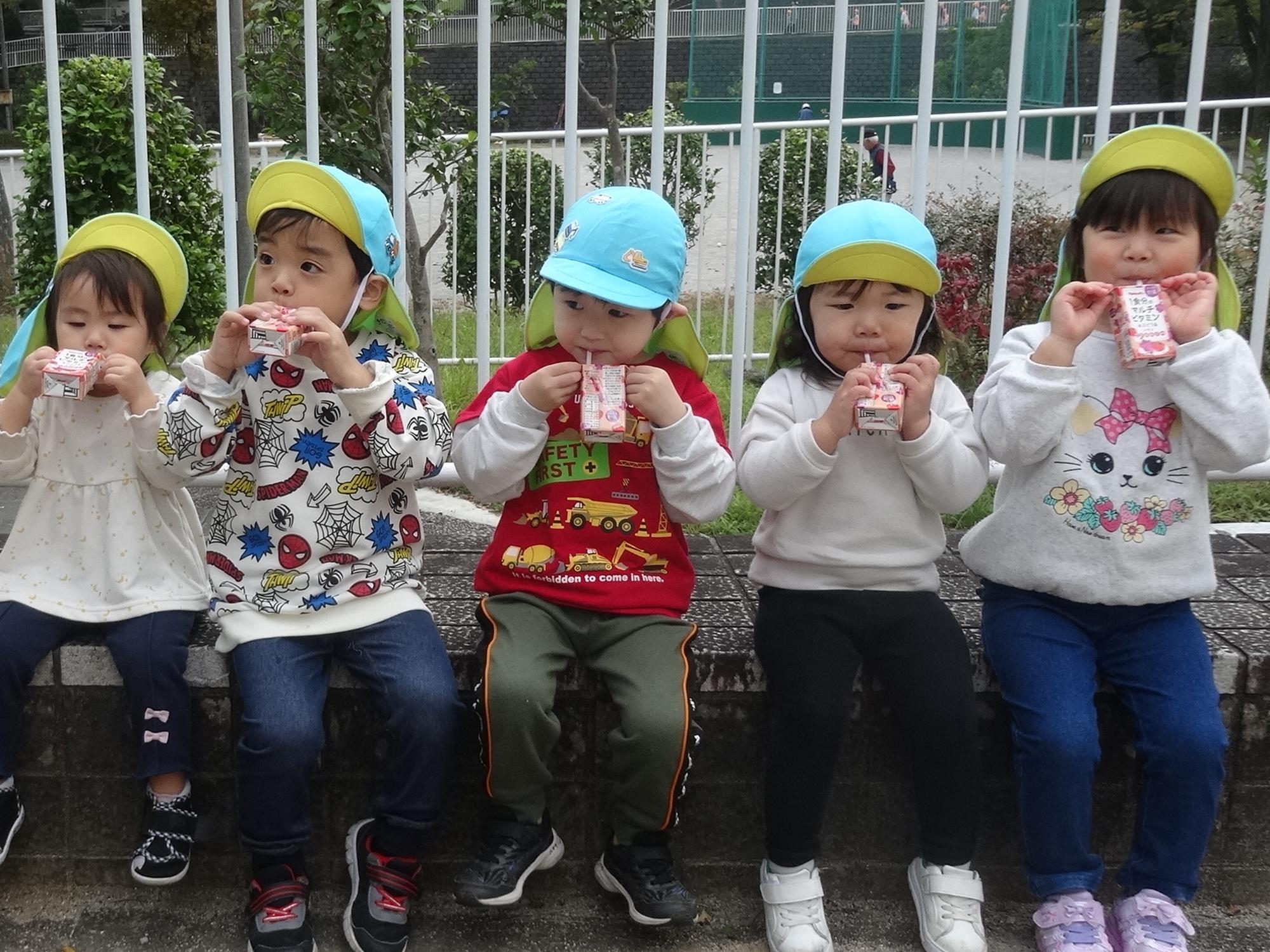 子どもたちがジュースを飲んでいる写真
