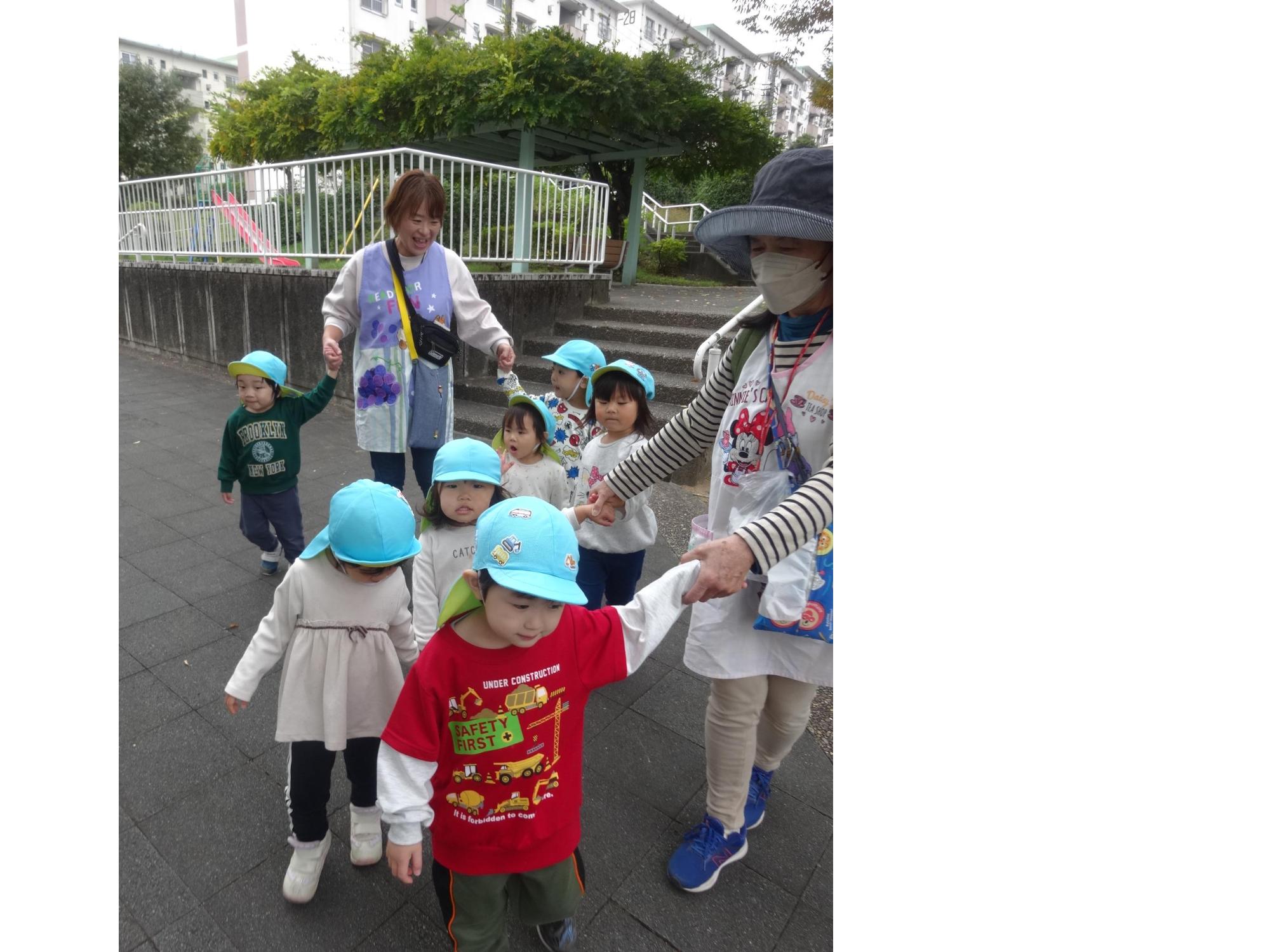 子ども達が手をつないで歩いている写真