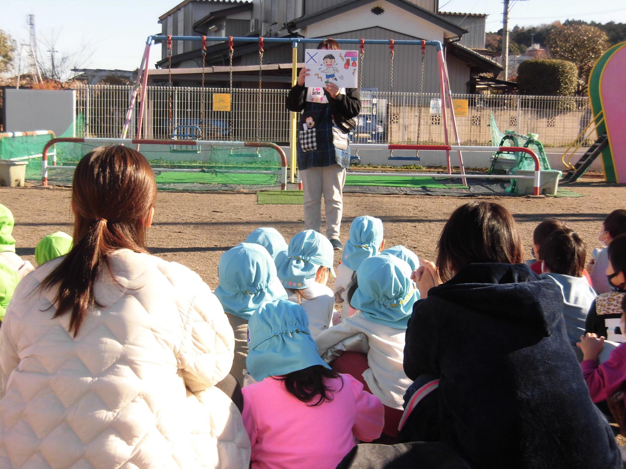 避難訓練で、避難時の約束のお話を子どもたちが聞いているところ