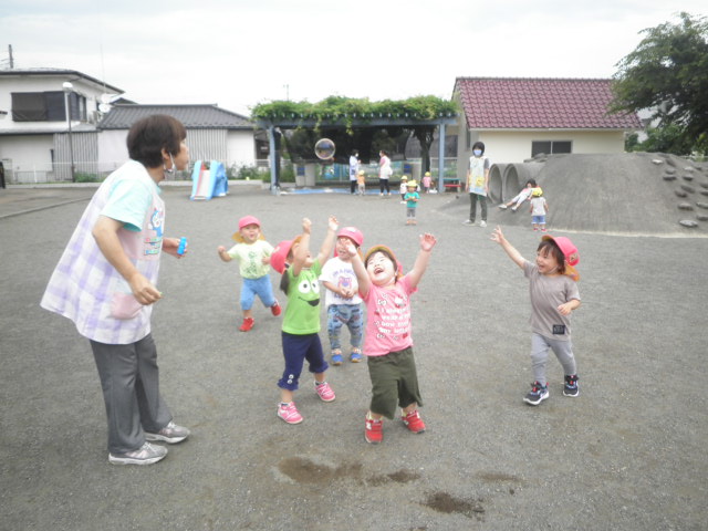 シャボン玉あそびを楽しむ2歳児（もも組）の写真