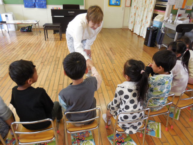 Mrs.栗原と子どもたちが握手をしている写真
