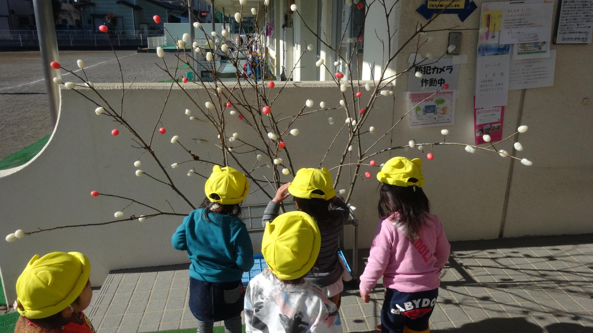 繭玉飾りを見ている子どもたち