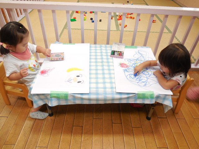 お絵描きを楽しむ子どもの写真